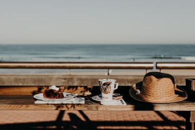Gouter en terrasse avec gateau au chocolat, café, et vue sur la mer